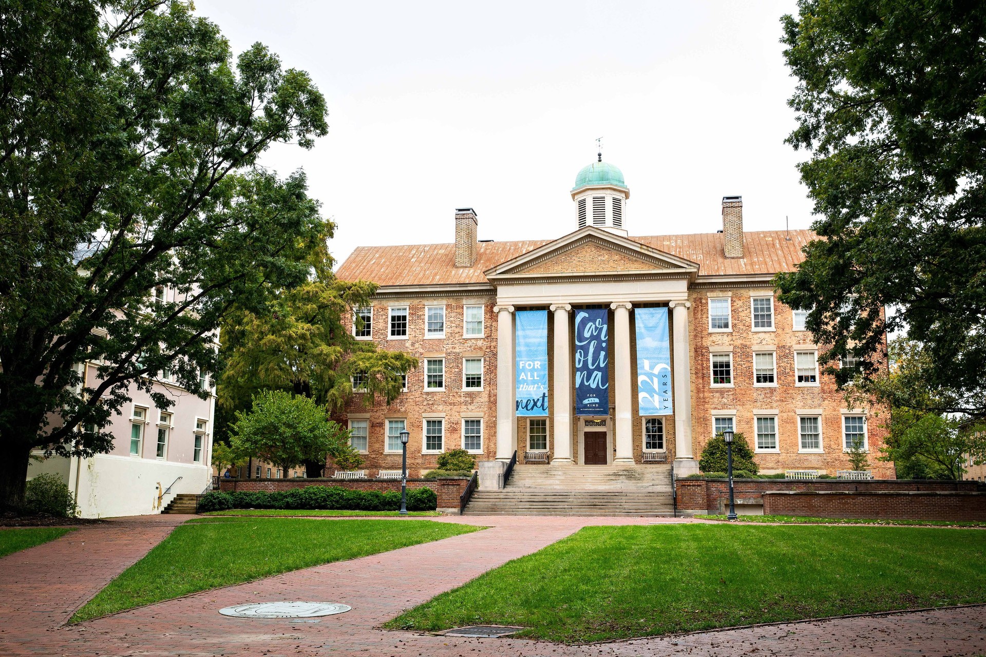 UNC's Chapel Hill South Building with school seal on brick walkway leading to entrance