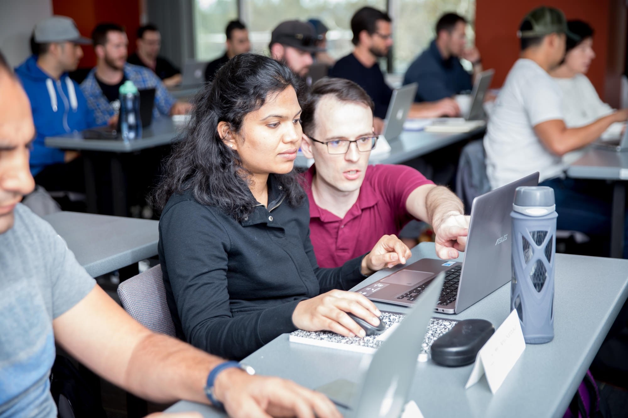 Instructor kneeling down to help student at computer