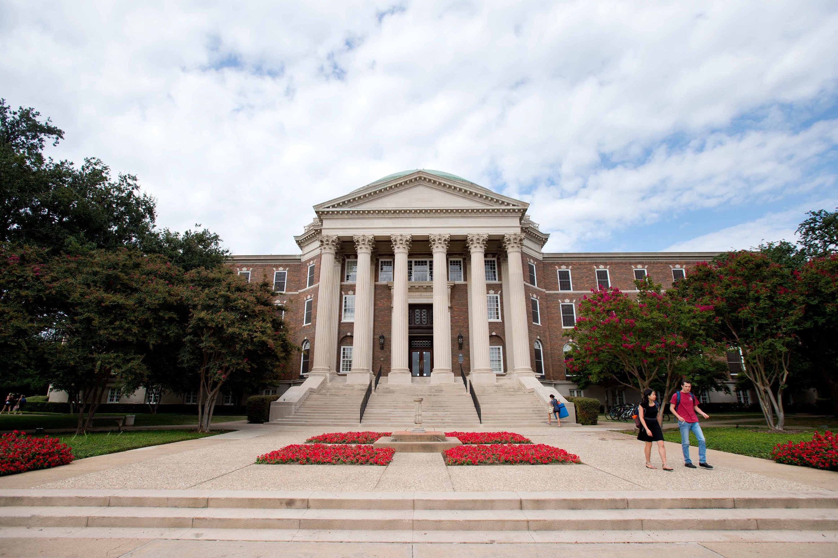 Students walking the stairs to Dallas Hall at Southern Methodist University on a cloudy day